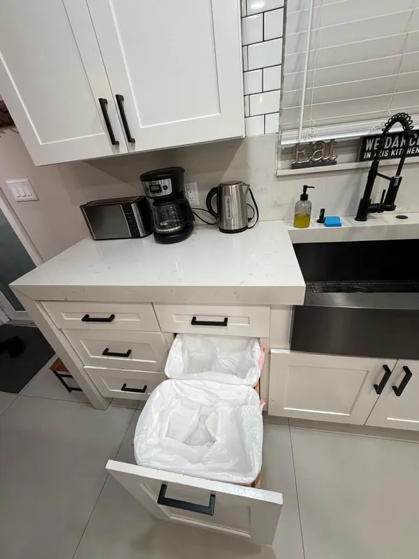 Kitchen trash drawer emptied with new bag liners after the turnover