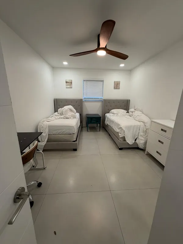 Bedroom with two unmade twin beds before cleaning